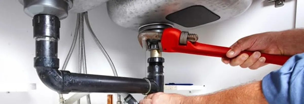 Garbage disposal repair technician tightening the sink drain and disposal connection in West Palm Beach, FL