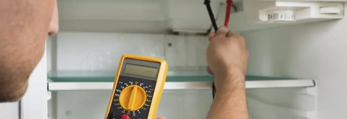 Refrigerator repair technician testing electrical components with a multimeter in West Palm Beach, FL