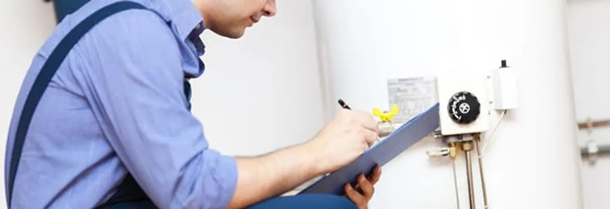 Water heater repair technician inspecting the unit and recording service notes in West Palm Beach, FL